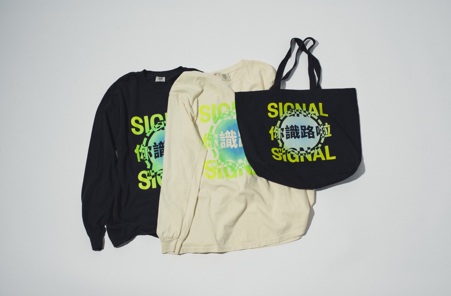 Two longsleeve shirts and a tote bag with stylized neon Signal logo and Cantonese characters reading '你識路啦'.